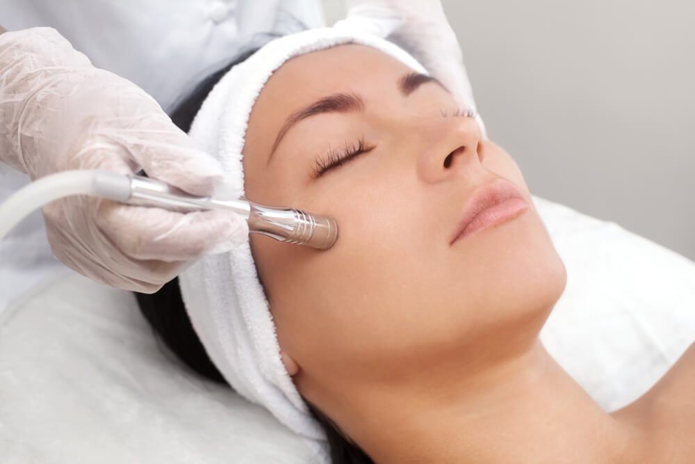 cosmetologist makes the procedure Microdermabrasion